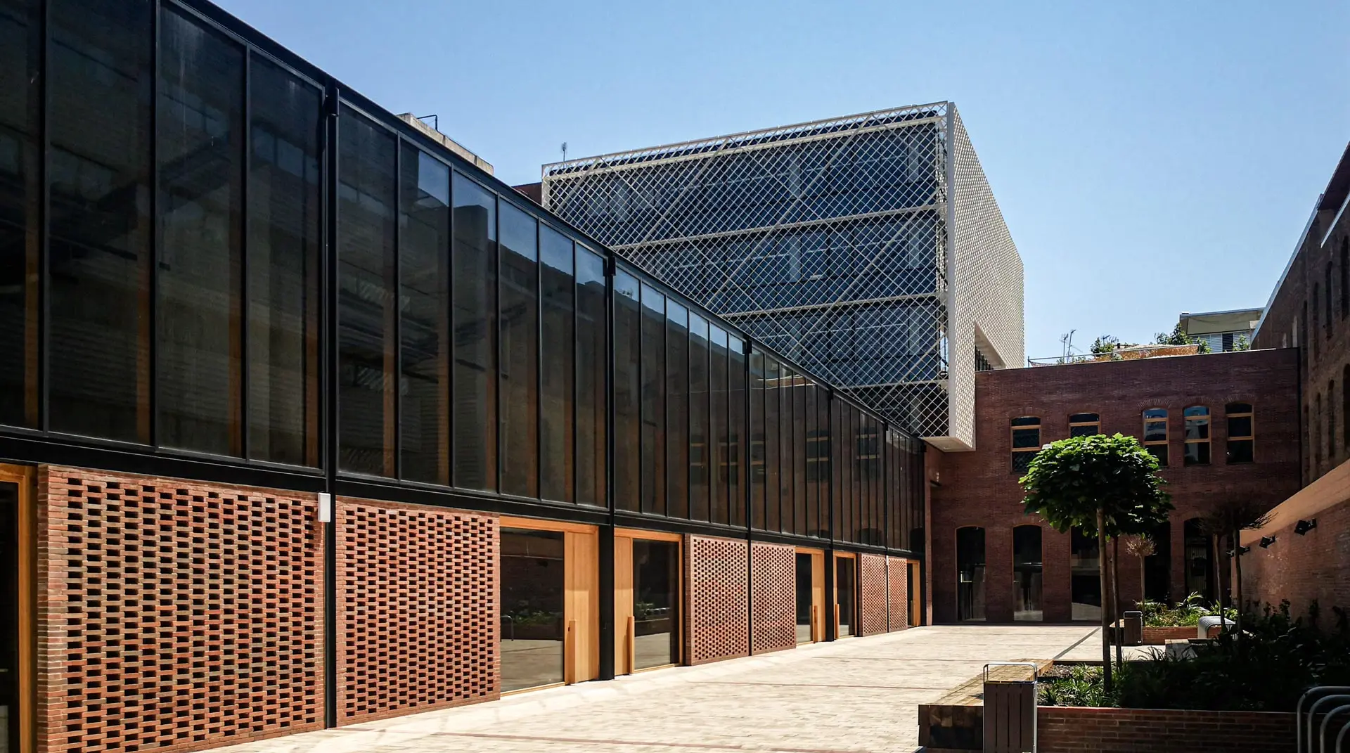 Proyecto lumínico y arquitectónico de Luxes en oficinas KNEM: diseño contemporáneo y eficiencia energética. Fachada de las oficinas KNEM con diseño arquitectónico moderno e iluminación natural, proyecto de Luxes.