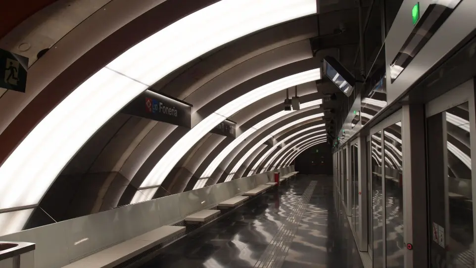 Diseño lumínico del andén principal de la estación Foneria, Metro de Barcelona, con luminarias integradas en la bóveda.