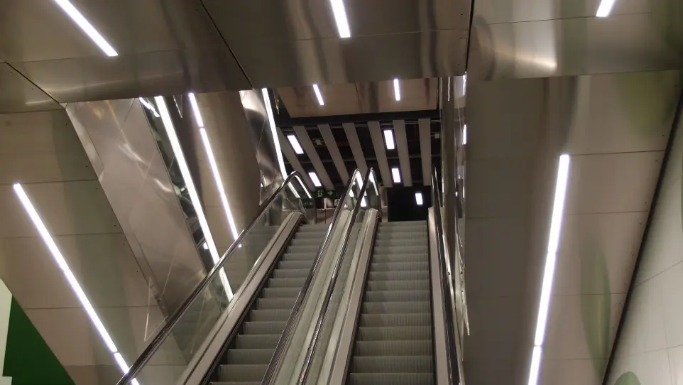 Luminarias lineales integradas en la zona de escaleras mecánicas de la estación de metro Foc, Barcelona.