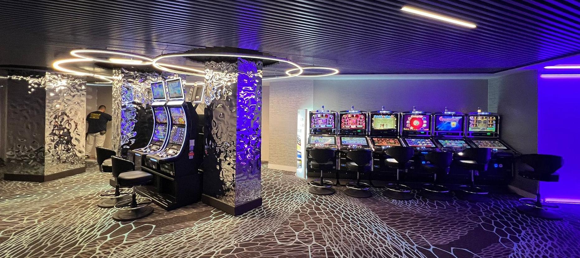 Zona de máquinas del Casino Marbella iluminada con tonos LED dinámicos en azul y violeta por Luxes.