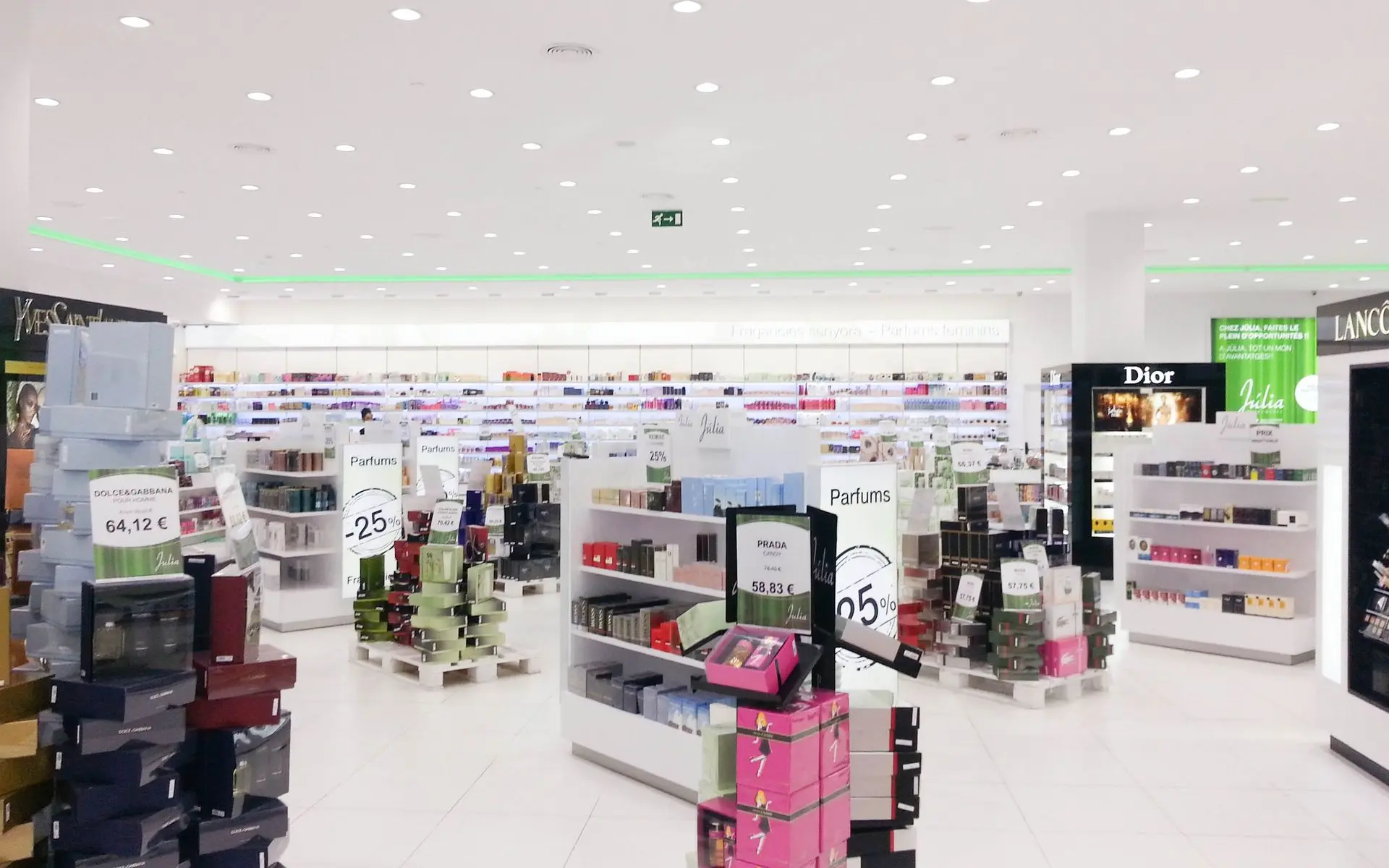 Iluminación técnica y decorativa en Perfumería Júlia con acentos verdes y luz LED uniforme.