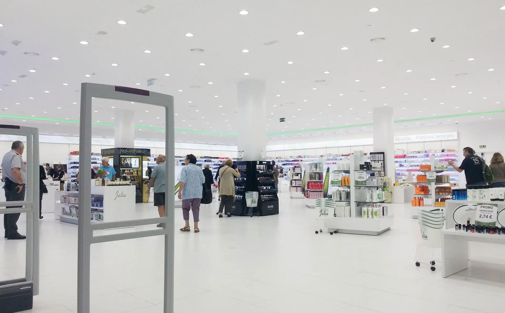 Iluminación técnica y decorativa en Perfumería Júlia con acentos verdes y luz LED uniforme.